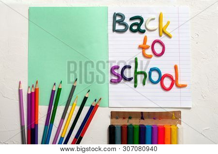 School Supplies And Inscription Back To School On Color Background