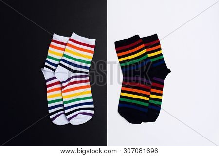 Two Negative White And Black Background With Two Pair Of Socks With Colorful Striped Pattern. Flat L