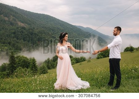 Beautiful Young Wedding Couple Standing On The Green Slope, Hill. Groom And Bride In Carpathian Moun