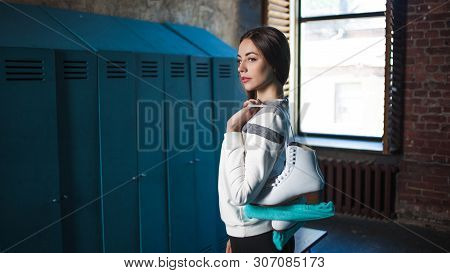Girl Skater With Figure Skates. Young Woman In The Locker Room, Skater Preparing For Training