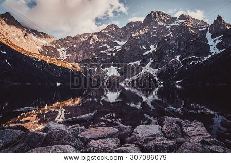 Breathtaking View To The Beautiful Mountains With Mirroed Reflection And Clouds At Sunset Time.