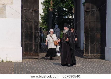 Sergiev Posad, Russia - June, 8, 2019: pastor speaking with congregates infront of the gates of Troitse-sergiyevsky Lavra (monastery) in Sergiev Posad, Russia