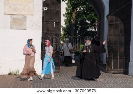 Sergiev Posad, Russia - June, 8, 2019: pastor speaking with congregates infront of the gates of Troitse-sergiyevsky Lavra (monastery) in Sergiev Posad, Russia
