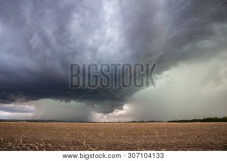 A Supercell Thunderstorm Dumps Heavy Rain And Hail Over An Empty Field.