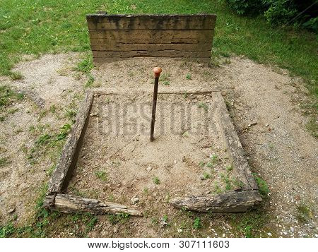 Metal Pole In Horseshoe Pit With Wood Backstop