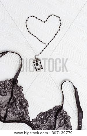 Fashionable Female Lace Bra And Figure Of Heart On Wooden Background. Top View On Black Guipure Ling