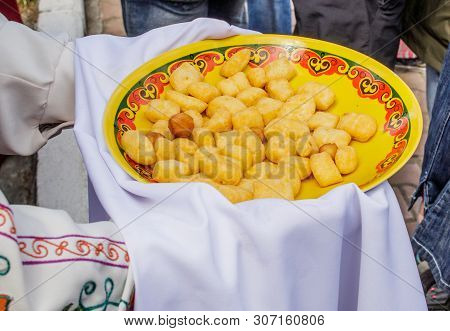 Oriental Cuisine. On The Hands Of A Person Bashkir Baursak Or Boortsog In A Plate With An Ethnic Pat