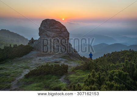 Sunrise With Fog In The Mountains. Two People Contemplate Beautiful Morning Scene.