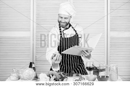 Book Family Recipes. According To Recipe. Man Bearded Chef Cooking Food. Guy Read Book Recipes. Culi