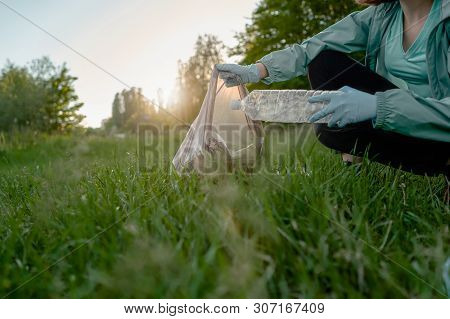Blogging Concept. The Girl Collects Trash From The Forest In The Trash Bag