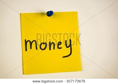 The Word Money On A Piece Of Yellow Paper Among Multicolored Paper
