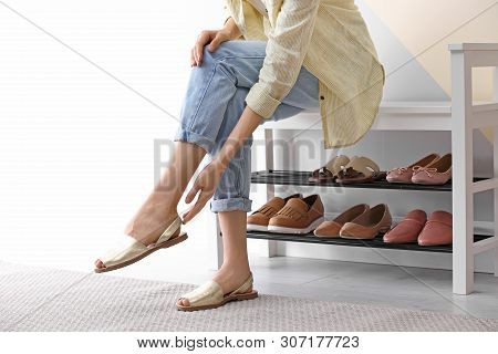 Woman Putting On Shoes Indoors, Closeup. Stylish Hallway Interior