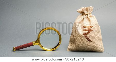 Money Bag With Rupee (rupiah) Sign And Magnifying Glass. The Concept Of Finding Sources Of Investmen