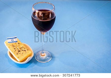 A Glass Of Red Wine With A Piece Of Blue Cheese On A Small Plate With A Tiny Flag Of Israel On A Lig