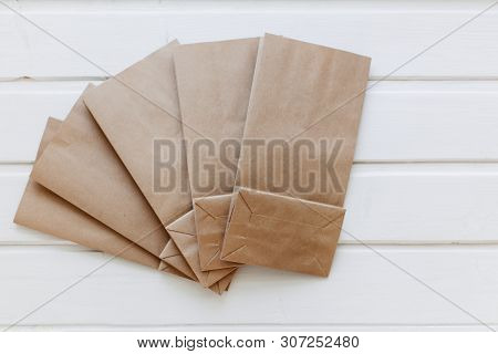 Paper Bags On Light Wooden Floor. Simple Brown Paper Bags For Lunch Or Meal. The Layout For The Desi