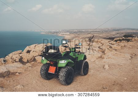 Green Atv Offroad On Sea And Sky Background. Cyprus Ayia Napa. Quad Bike For Rent For The Entertainm