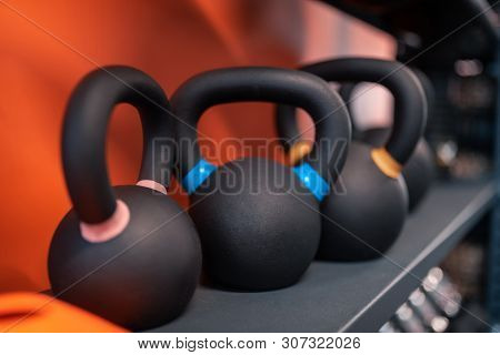 Different Kettlebells Lying On Shelf In The Fitness Center