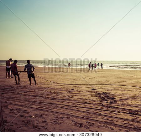 Goa, India - December 20, 2018: Fishermen Fishing With Nets On Morjim Beach