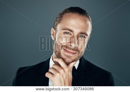 Just Thinking... Charming Young Man In Bow Tie Looking At Camera And Keeping Hand On Chin While Stan
