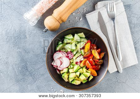 Vegan Buddha Bowl. Bowl With Fresh Raw Vegetables - Cherry Tomatoes, Cucumber, Radish, Avocado, Lett
