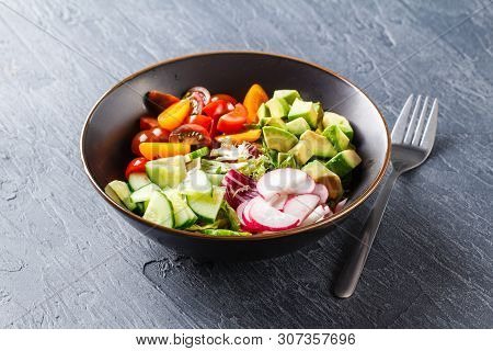 Vegan Buddha Bowl. Bowl With Fresh Raw Vegetables - Cherry Tomatoes, Cucumber, Radish, Avocado, Lett