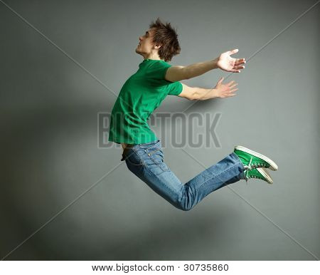 Artistic shot of a guy jumping high and posing meanwhile