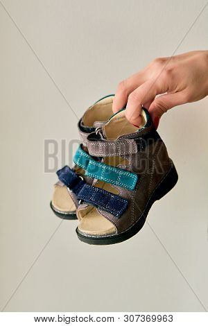 Female Is Holding Close-up A Special Childrens Orthopedic Shoe Sandals Made Of Genuine Leather.