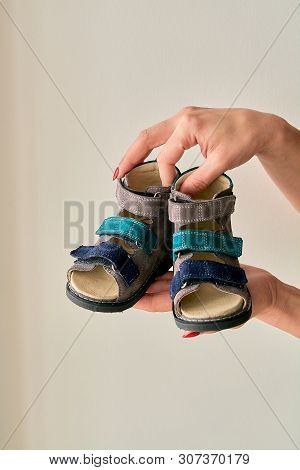 Female Is Holding Close-up A Special Childrens Orthopedic Shoe Sandals Made Of Genuine Leather.