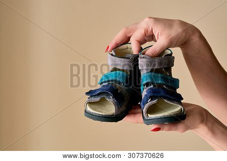 Female Is Holding Close-up A Special Childrens Orthopedic Shoe Sandals Made Of Genuine Leather.