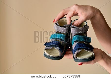 Female Is Holding Close-up A Special Childrens Orthopedic Shoe Sandals Made Of Genuine Leather.