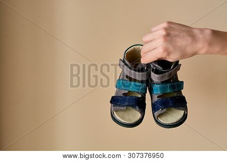 Female Is Holding Close-up A Special Childrens Orthopedic Shoe Sandals Made Of Genuine Leather.