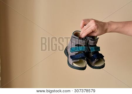 Female Is Holding Close-up A Special Childrens Orthopedic Shoe Sandals Made Of Genuine Leather.