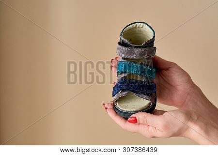 Female Is Holding Close-up A Special Childrens Orthopedic Shoe Sandals Made Of Genuine Leather.
