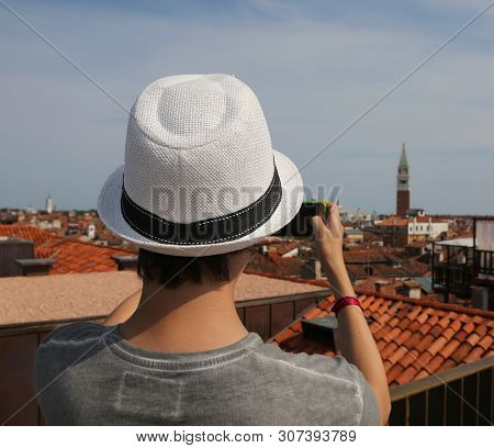 Boy With A Straw Hat Photographs The City Of Venice From Above