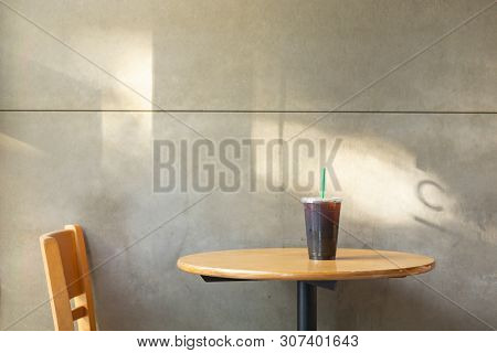 Take Away Plastic Cup Of Iced Black Coffee Americano On Wooden Table In The Restuarant