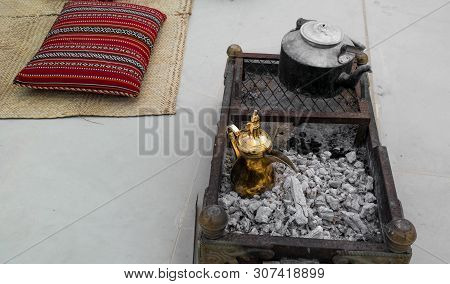 Making Traditional Arabian Coffee - Golden Arabic And Middle Eastern Coffee Pot (dallah) On Top Of C