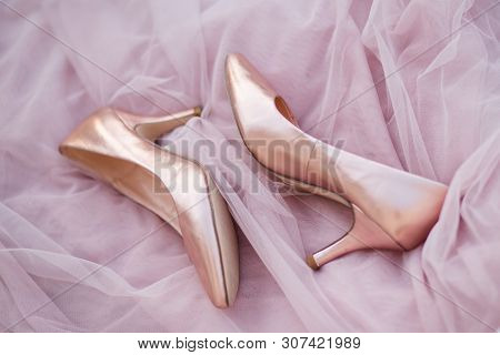 Pink Gold Bridal Shoes. Tender Beige Fatin Cloth Texture Background. Top View Of Ladys Pumps. Space 