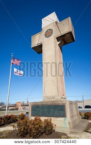 2019 BLADENSBURG MARYLAND USA FEB 25 Peace Cross: Low angle view of American Flag, 100th anniversary Flag at the World War I Memorial commissioned by the American Legion built 1919-1925 on Alt Rt 1.
