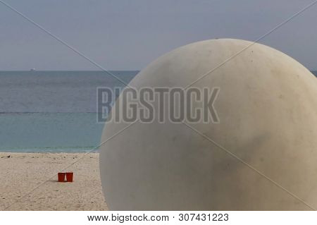In The Foreground Is The Beach Construction In The Form Of A Huge Concrete White Ball, In The Backgr