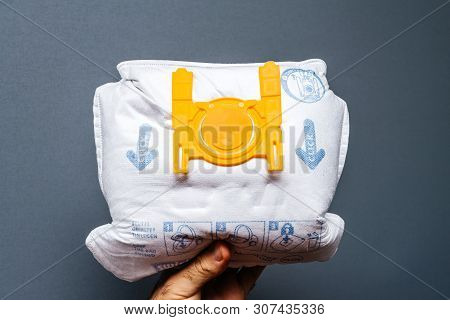 Paris, France - May 16, 2019: Man Hand Holding Against Gray Background Used Swirl Vacuum Cleaner Bag