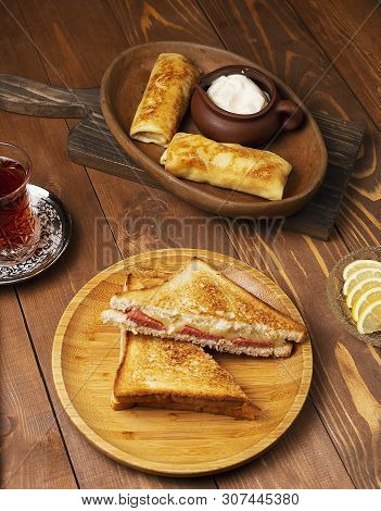 Club Sandwiches With Salami, Bacon And Blinchik Served With Yogurt In Wooden Plate With Tea.image