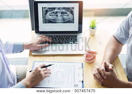 Dental Hygienist Demonstrating And Showing A Dummy Jaw To Chack-up Or Healing Teeth  Patient