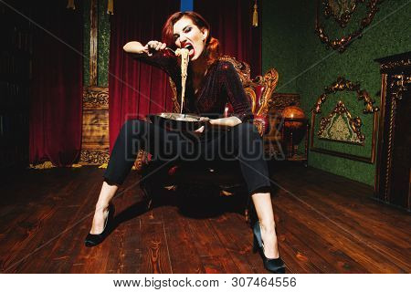 A full length portrait of a beautiful woman posing in the vintage interior and having a meal. Beauty, fashion, interior.