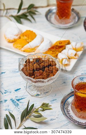 Tea Set With Varieties Of Traditional Nuts, Lemon, Confiture And Sweets Served On White Tablecloth -