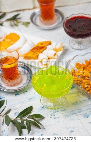 Tea Set With Varieties Of Traditional Nuts, Lemon, Confiture And Sweets Served On White Tablecloth -