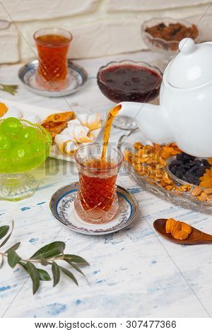 Tea Set With Varieties Of Traditional Nuts, Lemon, Confiture And Sweets Served On White Tablecloth -