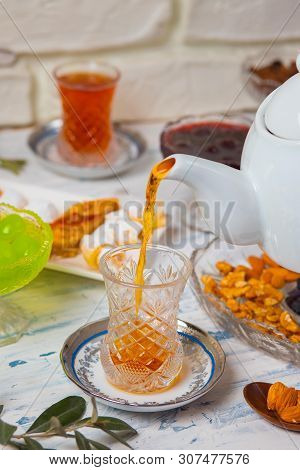 Tea Set With Varieties Of Traditional Nuts, Lemon, Confiture And Sweets Served On White Tablecloth -