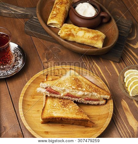 Club Sandwiches With Salami, Bacon And Blinchik Served With Yogurt In Wooden Plate With Tea.image