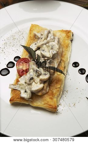 Mushtoom Sauteed, Chicken Stroganoff On A Piece Of Bread. Antipasta In A Decorated White Plate With 