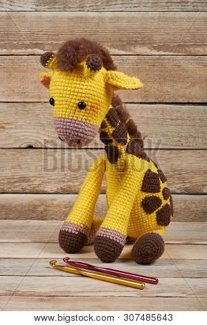 Crocheted Toy Giraffe On A Wooden Background
